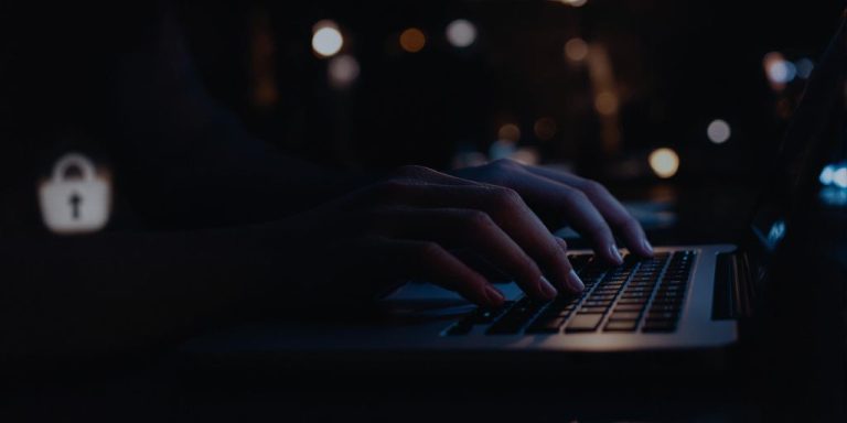 Person typing on laptop in a secure environment.